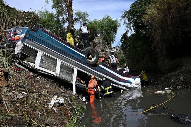 Firefighters in Guatemala City work at the scene where a bus veered off a bridge and into a ravine on Monday, February 10, 2025. At least 54 people were killed. (Photo by Johan Ordonez/AFP Photo)