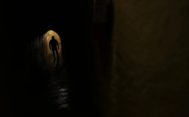 This October 28, 2017 photo shows blind waiter Oscar Pitiur walking in “La Cueva de Rafa”, or Rafa's Cave restaurant, located 12 meters underground in Quito, Ecuador. On the outskirts of Ecuador's capital, young couples and families venture into a pitch-black cave in search of an unlikely experience: a meal in the dark. (Photo by Dolores Ochoa/AP Photo)
