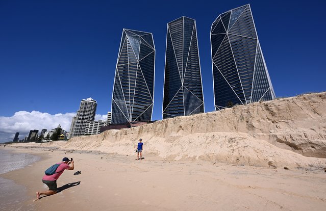 A tourist has their photo taken against a backdrop of beach erosion at Broadbeach on the Gold Coast, Australia, 13 March 2025. As the recovery from ex-tropical cyclone Alfred's devastating impact ramps up, tourists are being urged to maintain their Easter holiday plans. (Photo by Dave Hunt/EPA/EFE)