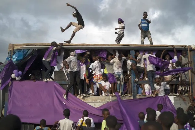 Supporters of presidential candidate Kouadio Konan Bertin dance in and on a sound truck during the final campaign rally in Abidjan, Ivory Coast, Thursday, October 29, 2020. Bertin, known as KKB, has presented his candidacy as an independent candidate for the upcoming Oct. 31 election, and said he would not join the boycott proposed by two main opponents of Ivory Coast President Alassane Ouattara. (Photo by Leo Correa/AP Photo)