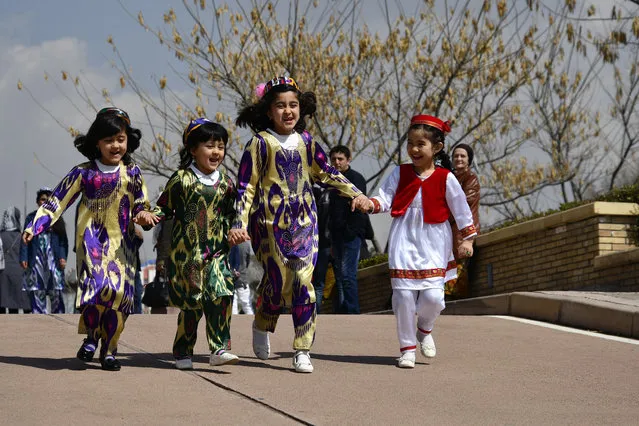 A picture taken on March 19, 2017 shows young Tajik girls wearing traditional dresses celebrating the spring Nowruz festival in Dushanbe. Clothing factories in Tajikistan are churning out brightly coloured national dresses amid a surge in sales, and it's not just because of the arrival of spring. (Photo by Nozim Kalandarov/AFP Photo)