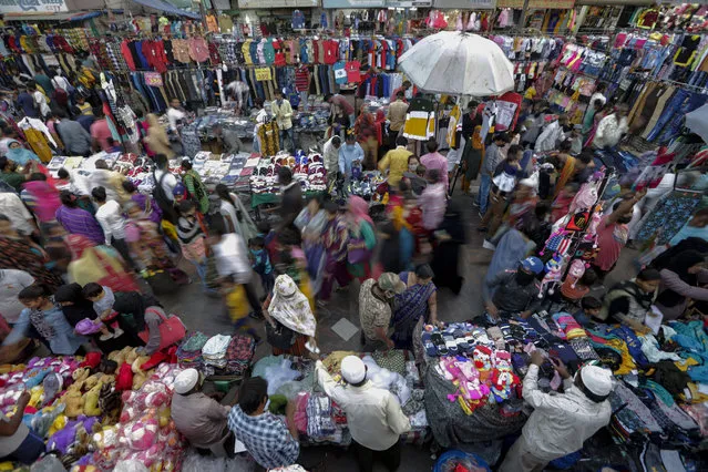 Indians throng a market for shopping ahead of Hindu festival Diwali in Ahmedabad, India, Monday, November 9, 2020. India's tally of coronavirus cases is currently the second largest in the world behind the United States. The government warns that the situation can worsen due to people crowding markets for festival shopping. (Photo by Ajit Solanki/AP Photo)