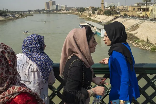 Women stand on the “martyrs' bridge” spanning the Tigris River in Baghdad, Iraq, Friday, February 24, 2023. (Photo by Jerome Delay/AP Photo)