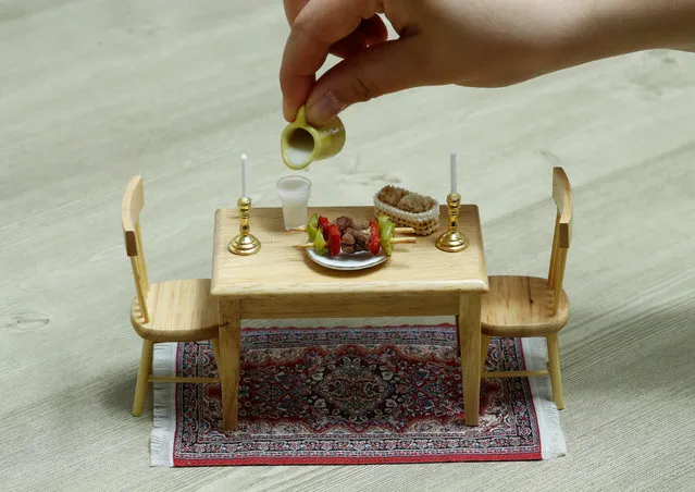 A dining table with a meat dish prepared by miniature food cook Burcu Celenoglu Aydin is pictured at her mini kitchen in Istanbul, Turkey on April 11, 2018. (Photo by Murad Sezer/Reuters)
