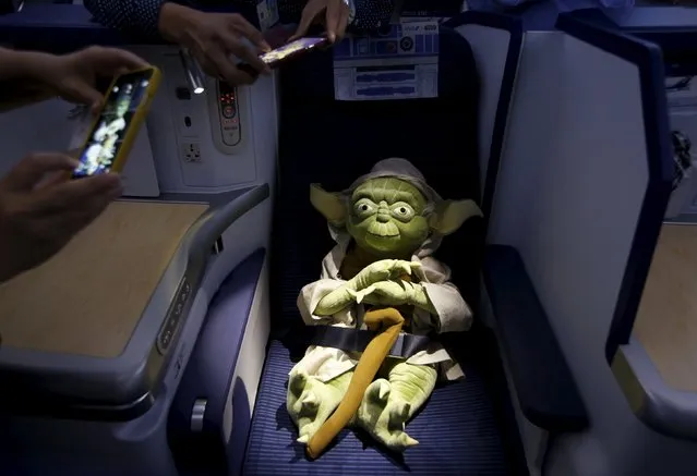 Visitors take photos of a Yoda plush toy sitting in the business class section during a tour of the Star Wars themed All Nippon Airways ANA R2D2 Boeing 787 Dreamliner aircraft at Singapore's Changi Airport November 12, 2015. (Photo by Edgar Su/Reuters)
