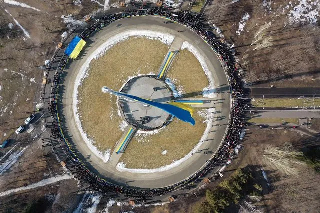 An aerial view shows people holding flags and gathering at Juvileyniy Park to mark “Unity day” in Kramatorsk city of Donetsk Oblast, Ukraine on February 16, 2022. (Photo by Ali Atmaca/Anadolu Agency via Getty Images)