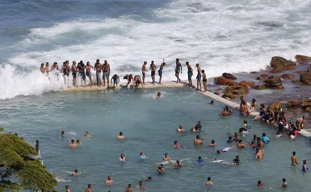 People enjoy the warm summer weather as they celebrate New Year's Day in a tidal pool at Cape Town's St James beach, January 1, 2015. (Photo by Mike Hutchings/Reuters)