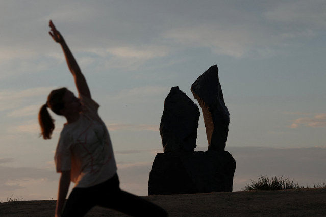 A woman practices yoga near a sculpture titled “Tokatuwai/Stand Strong in Water” by artist Anton Forde on the opening day of the “Sculpture by the Sea” outdoor exhibition in Bondi, Australia, on October 17, 2025. (Photo by Hollie Adams/Reuters)
