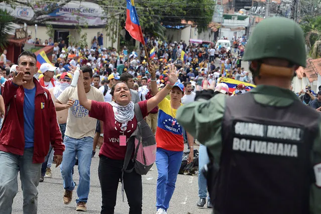 Demonstrators shout slogans in front of Venezuelan National Guard members during a rally demanding a referendum to remove Venezuela's President Nicolas Maduro in San Cristobal, Venezuela October 26, 2016. (Photo by Carlos Eduardo Ramirez/Reuters)