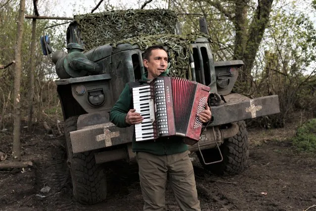 A serviceman of Ukrainian 80th separate airborne assault brigade, plays accordion during the rest on the front line near Bakhmut in Donetsk region on April 18, 2023, amid the Russian invasion of Ukraine. (Photo by Anatolii Stepanov/AFP Photo)