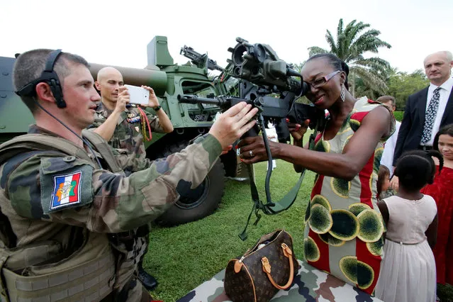 A French woman tests an automatic rifle on display during a visit by France's Prime Minister Manuel Valls to the 43rd Marine Infantry Battalion, a unit of the French army based in Abidjan, Ivory Coast October 30, 2016. (Photo by Thierry Gouegnon/Reuters)