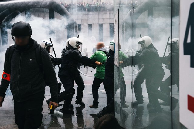 Protestors clash with Belgian riot police officers during a national day of action against the austerity of the federal Arizona government, in Brussels on October 14, 2025. The strike is the last in a series to hit the European country since Flemish nationalist Bart De Wever took office as prime minister in February. Grappling with a budget deficit whose size violates European Union rules, the government is looking to reform pensions and make other savings that have infuriated trade unions. (Photo by Marius Burgelman/Belga via AFP Photo)