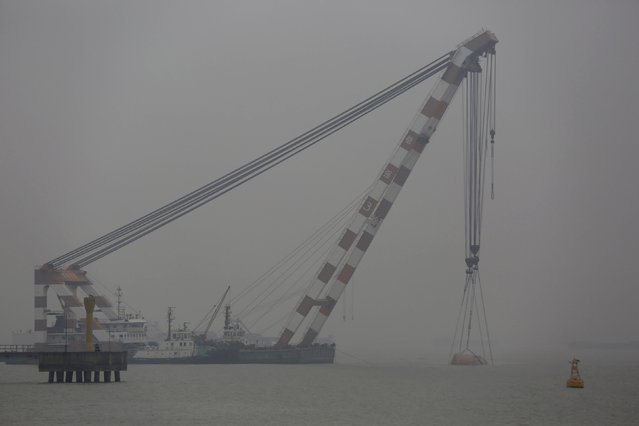 A sunken tug boat is lifted from the Yangtze River by a rescue team near Jingjiang, Jiangsu province, January 16, 2015. (Photo by Aly Song/Reuters)