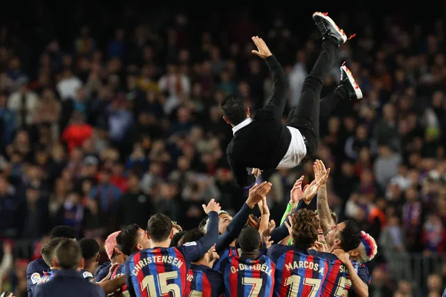 Barcelona's players throw Barcelona's Spanish coach Xavi (Top) in the air as they celebrate after the Spanish league football match between FC Barcelona and Real Sociedad at the Camp Nou stadium in Barcelona on May 20, 2023. The new La Liga champions Barcelona tumbled to a 2-1 defeat by Real Sociedad before they were presented with their trophy at the Camp Nou stadium, as the Basque visitors defended their hold on fourth place. (Photo by Lluis Gene/AFP Photo)