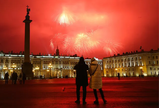 People in Palace Square watch a firework display over central St Petersburg marking the 77th anniversary of the end of the Leningrad Siege in St Petersburg, Russia on January 27, 2021. During WWII, St Petersburg (then known as Leningrad) withstood a 872-day siege by Nazi forces and was liberated by the Soviet Army in January 1944. (Photo by Peter Kovalev/TASS)