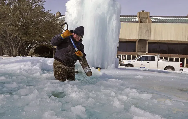 City of Richardson worker Kaleb Love breaks ice on a frozen fountain Tuesday, February 16, 2021, in Richardson, Texas. Temperatures dropped into the single digits as snow shut down air travel and grocery stores. (Photo by L.M. Otero/AP Photo)