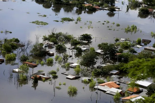Houses are partially submerged in floodwaters in Asuncion, December 20, 2015. (Photo by Jorge Adorno/Reuters)