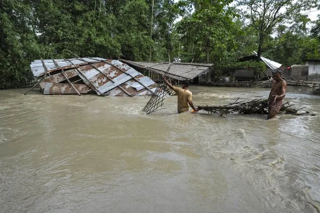 Villagers salvage belongings from their flood-damaged houses in Bali village, west of Guwahati, India, Friday, June 23, 2023. Tens of thousands of people have moved to relief camps with one person swept to death by flood waters caused by heavy monsoon rains battering swathes of villages in India’s remote northeast this week, a government relief agency said on Friday. (Photo by Anupam Nath/AP Photo)