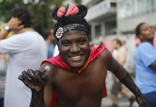 A reveler holds a magic wand man as he poses for a photo during the Banda de Ipanema carnival parade in Rio de Janeiro, Brazil, Saturday, January 31, 2015. (Photo by Silvia Izquierdo/AP Photo)