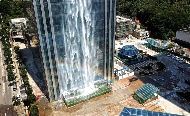 This photo taken on July 20, 2018 shows a rainbow caused by a 108- meter- high (350 feet) artificial waterfall on the facade of the Liebian International Building in Guiyang in China' s southwestern Guizhou province. A skyscraper in southwestern China that boasts what its owner calls the world' s largest man- made waterfall has become the latest example of over- the- top architecture to draw national ridicule. (Photo by AFP Photo/Stringer)