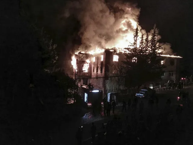 Flames rise from a fire in a school dormitory, in Aladag, Adana in southern Turkey, Tuesday, November 29, 2916. A fire at a middle school dormitory for girls in southern Turkey has left over ten people dead and over a dozen injured, a Turkish governor and state-run media said. (Photo by DHA via AP Photo)