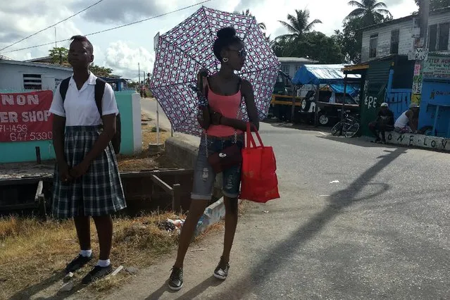 Girls stand by the side of the road in Georgetown, Guyana December 5, 2016. (Photo by Carlo Allegri/Reuters)