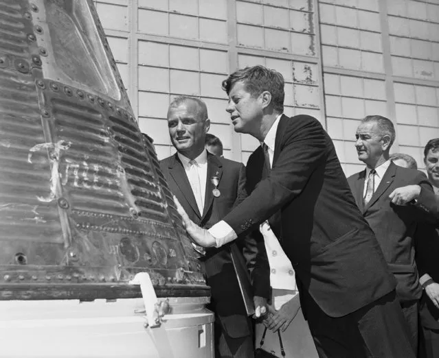 In this February 23, 1962 file photo, astronaut John Glenn and President John F. Kennedy inspect the Friendship 7, the Mercury capsule in which Glenn became the first American to orbit the Earth. Kennedy presented Distinguished Service medal to Glenn at Cape Canaveral, Fla. At right is Vice President Lyndon Johnson. (Photo by Vincent P. Connolly/AP Photo)