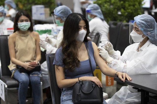 Health workers administer shots of the Sinovac COVID-19 vaccine for airline employees at Siam Paragon shopping mall in Bangkok, Thailand, Tuesday, May 25, 2021. (Photo by Sakchai Lalit/AP Photo)