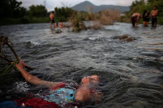 Jensi, a 14 year old migrant girl from Honduras, baths in a fresh water stream as she and others, part of caravan of thousands from Central America en route to the United States, take rest in Pijijiapan, Mexico October 25, 2018. Picture taken October 25, 2018. (Photo by Adrees Latif/Reuters)