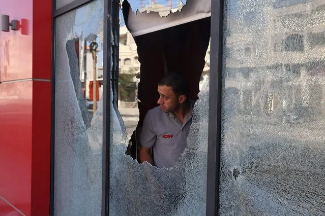 A Palestinian man inspects the damage to a store in the village of Huwara in the Israeli-occupied West Bank on October 6, 2023, after an overnight attack by Israeli settlers. Dozens of Israeli civilians gathered in an area of Huwara and engaged in stone-throwing clashes with Palestinians, the Israeli army said, before soldiers intervened with “riot dispersal means to defuse the confrontation”. (Photo by Jaafar Ashtiyeh/AFP Photo)
