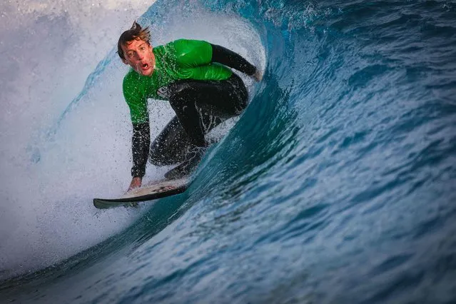 Mark Spencer of the Royal Navy Marines rides in the barrell of a wave during the English Interclub Surfing Championships at The Wave, an inland surfing complex near Bristol, south west England on October 7, 2023. Surf clubs from across England compete on advanced settings on the Wave, a 'slice of the ocean' that brings surfing inland for people of all ages and abilities. The world-first wavepool uses innovative technology that provides up to 1,000 waves of varying sizes from white water for beginners, to 2 metre barrelling waves for professional surfers. It was the first destination of its kind to open in the world and is powered by Wavegarden Cove technology. (Photo by Adrian Dennis/AFP Photo)