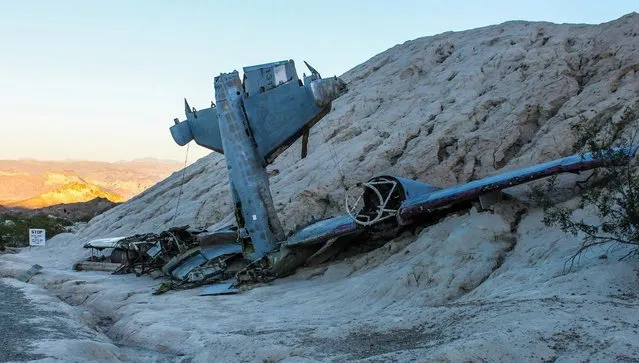 Images of an American ghost town that was home to gold mines and features a plane which crashed during the filming of 3000 Miles to Graceland starring Kevin Costner and Kurt Russell reveal the remnants of the once thriving location. An assortment of rusted vehicles which include a canary yellow bus, caravans and cars have all been left behind in the desert. Other pictures of Nelson, Nevada show its desolate surroundings with only a couple of houses and museums scattered around the area. In one shot, a derelict petrol pump stands still after making its final sale years ago. The stunning photographs were taken by an American photographer known as Abandoned Southeast on a visit to Nelson, Nevada. The area was called Eldorado by the Spaniards who made the original discoveries of gold in the town. The notorious Techatticup gold and silver mine which was associated with crime and murders ran in the area from 1861 to 1942. It was the richest mine in Southern Nevada. (Photo by Abandoned Southeast/Mediadrumworld.com)