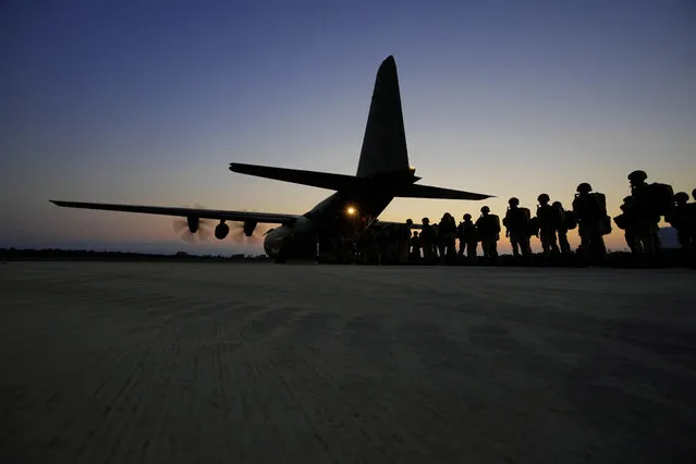 British paratroopers with the 16th Air Assault Brigade line up to board a C-130 transport aircraft at RAF Akrotiri air base in Cyprus for an airdrop over Jordan as part of a joint exercise with Jordanian soldiers on Wednesday, June 23, 2021. (Photo by Petros Karadjias/AP Photo)