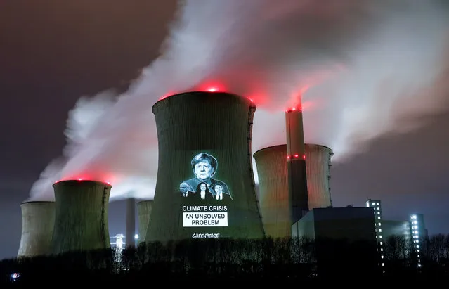 Greenpeace activists project images of German Chancellor Angela Merkel (top), German Economy minister Peter Altmaier, SPD chairwoman Andrea Nahles and German Transport minister Andreas Scheuer (L-R) with a slogan onto a cooling tower of the brown coal power plant of RWE, one of Europe's biggest utilities in Neurath, north-west of Cologne, Germany, December 14, 2018. (Photo by Wolfgang Rattay/Reuters)
