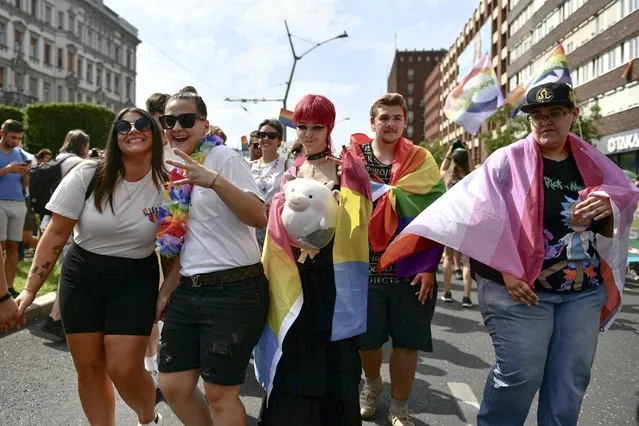 People taking part in a gay pride parade pose before the start of the event in Budapest, Hungary, Saturday, July 24, 2021. Hungary's government led by right-wing Prime Minister Viktor Orban passed a law in June prohibiting the display of content depicting homosexuality or gender reassignment to minors, a move that has ignited intense opposition in Hungary while EU lawmakers have urged the European Commission to take swift action against Hungary unless it changes tack. (Photo by Anna Szilagyi/AP Photo)