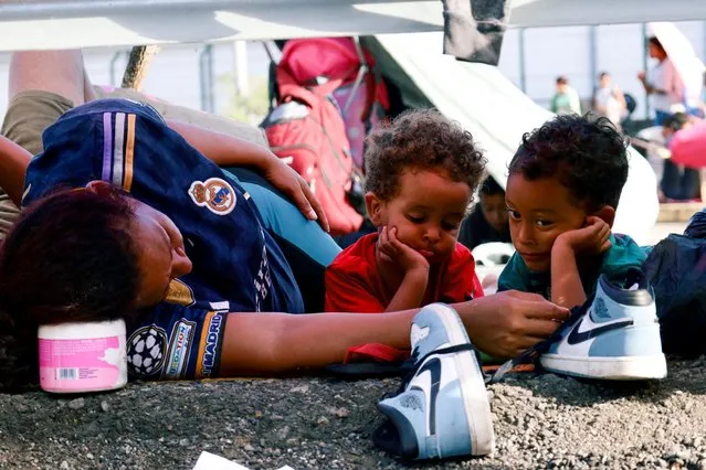 A woman and children rest, as migrants hold a protest blocking a highway demanding authorities free transit through Mexico, as they attempt to reach the U.S. border, in Huixtla, Mexico on November 8, 2023. (Photo by Jose Torres/Reuters)