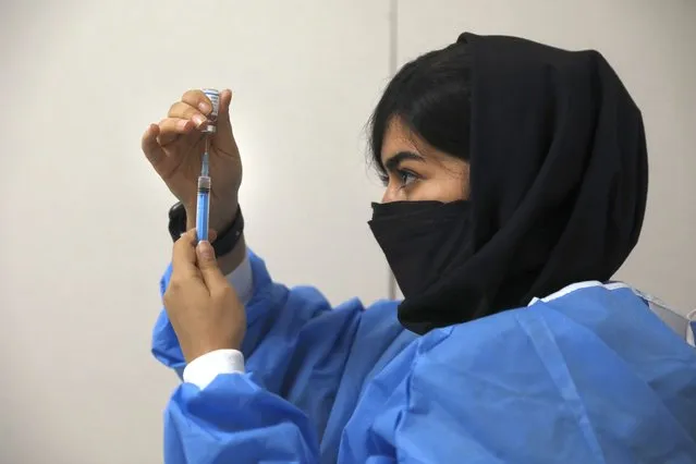 A health worker prepares a shot of Covid-19 vaccine for a citizen at a vaccination center in Iran Mall shopping center in Tehran, Iran, Monday, August 9, 2021. Iran – like much of the world – remains far behind countries like the United States in vaccinating its public. So far only 3 million people out of Iran's population of 80 million have had both vaccine doses. (Photo by Vahid Salemi/AP Photo)