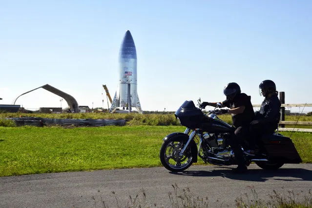 In this January 12, 2019 file photo, a motorcyclist rides near the SpaceX prototype Starship hopper at the Boca Chica Beach site in Texas. SpaceX says it will build its Mars spaceship in south Texas instead of the Port of Los Angeles, dealing another blow to the local economy only days after the company announced massive layoffs. The Southern California-based company announced Wednesday, January 16, 2019 that test versions of its Starship and Super Heavy rocket will be assembled at its Texas launch facility in a move to streamline operations. (Photo by Miguel Roberts/The Brownsville Herald via AP Photo)