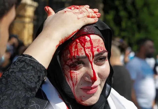 A Shi'ite Muslim woman bleeds after she was cut on the forehead with a razor during a religious procession to mark Ashura in Nabatieh, southern Lebanon on August 19, 2021. (Photo by Aziz Taher/Reuters)