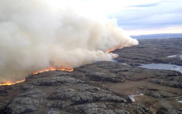 In this photo taken from a helicopter, a major fire burns across open land Wednesday January 29, 2014, in the county of Soer-Troendelag on the north western coast of Norway. This is the third major fire to hit Norway over the last few days, with people in the area being evacuated as a precautionary measure. (Photo by AP Photo/Helitrans via NTB scanpix)