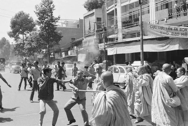 Two stick-wielding plainclothes policemen fight South Vietnamese Buddhist nuns in Saigon, Sunday, Jan. 26, 1975 during anti government demonstration. Officer (left) warns comrade that nun (background) is about to hit him with sandal. Melee occurred following political convention at pagoda. (Photo by Nguyen Tu A/AP Photo)