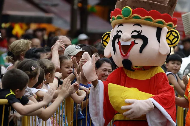 A God of Fortune mascot entertains the crowd during the Chinese New Year Celebrations 2014 Official Light-Up and Opening Ceremony in Chinatown on January 11, 2014 in Singapore. (Photo by Suhaimi Abdullah/Getty Images)