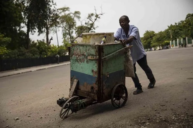 A man pushes a cart to sell individual servings of drinking water near the National Palace in Port-au-Prince, Haiti, Monday, October 4, 2021. (Photo by Rodrigo Abd/AP Photo)