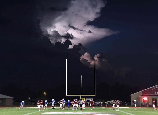 Lightning illuminates a storm cloud over fifty miles to the south as Jim Ned and Stamford high schools play a football scrimmage Thursday, August 19, 2021, in Tuscola, Texas. (Photo by Ronald W. Erdrich/The Abilene Reporter-News via AP Photo)