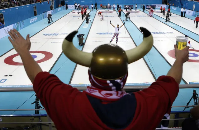 Norway's skip Thomas Ulsrud acknowledges the cheers of fan Rune Eikeland during men's curling competition against China at the 2014 Winter Olympics, Friday, February 14, 2014, in Sochi, Russia. (Photo by Robert F. Bukaty/AP Photo)