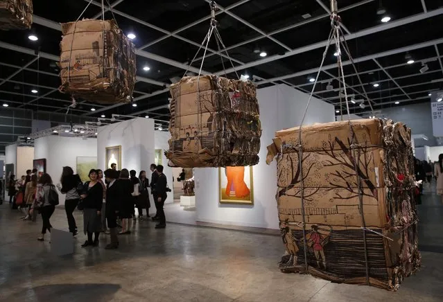 An artwork created by Indonesian artist Tintin Wulia is displayed during the VIP preview of the art fair “Art Basel” in Hong Kong, Tuesday, March 22, 2016. Wulia's collection of cardboard bales is the result of her yearlong investigation into a recycling micro-economy involving scrap collectors and Filipino migrant domestic workers who spend their days off in the heart of Hong Kong's financial district. She said the project examines how the material links seemingly unrelated groups in Hong Kong society and also symbolizes the city's widening wealth gap. (Photo by Kin Cheung/AP Photo)
