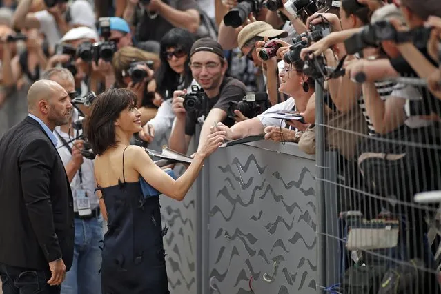 Jury member actress Sophie Marceau signs autographs to cinema fan as she arrives to attend a photocall before the opening of the 68th Cannes Film Festival in Cannes, southern France, May 13, 2015. The 68th edition of the film festival will run from May 13 to May 24. (Photo by Benoit Tessier/Reuters)