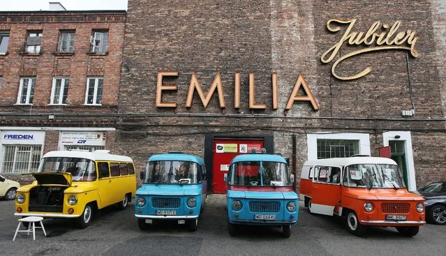 In this April 28, 2015 photo, communist-era Polish made Nysa vans appear on display in front of a wall with old neon store names near the Charm of PRL museum in Warsaw, Poland. (Photo by Czarek Sokolowski/AP Photo)