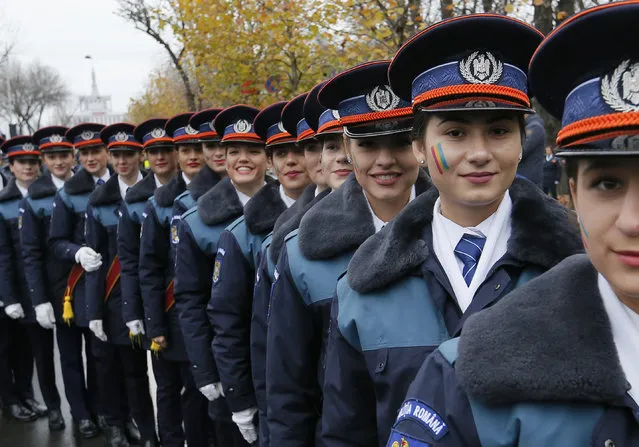 Young female cadets from the Police Academy, having national flag colors painted on their faces, during a military parade marking Romania's Great Union Day, in Bucharest, Romania, 01 December 2017. (Photo by Robert Ghement/EPA/EFE)