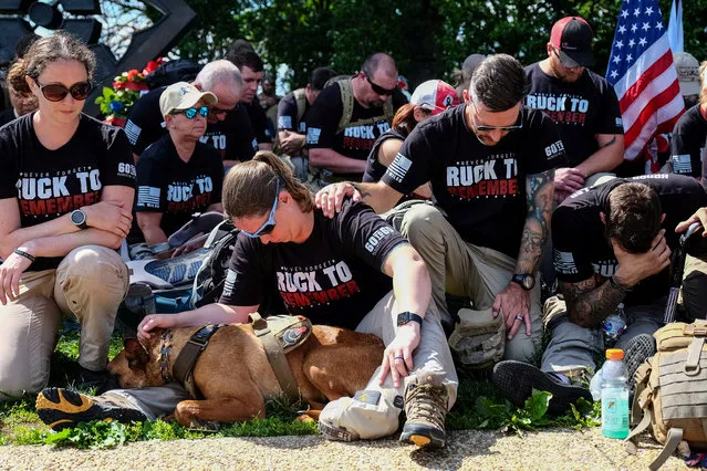 Air Force Veteran Sabrina Weber of Alabama, hugs her service dog durning a moment of silence in remembrance of Memorial Day at the Arlington National Cemetery, in Arlington, Virginia, U.S. May 27, 2019. (Photo by Michael A. McCoy/Reuters)